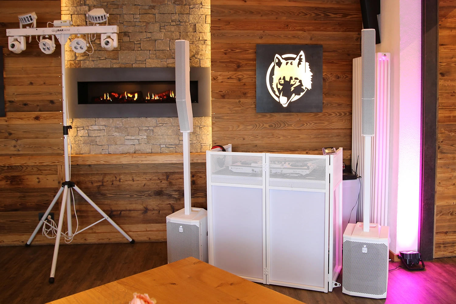 Die stilvolle weiße DJ-Anlage von Hochzeits-DJ Jürgen steht vor indirekt beleuchteter Holzwand.